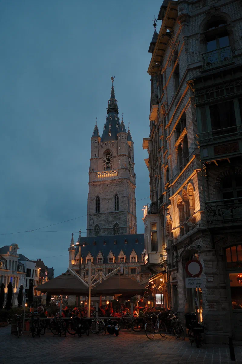 Stayed out until blue hour, when the terraces fill and the Belfry is lit.