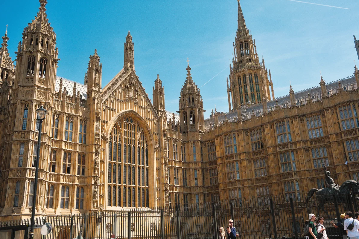 The Gothic Revival front of the Palace of Westminster on Old Palace Yard, Richard the Lionheart on horseback at its foot.